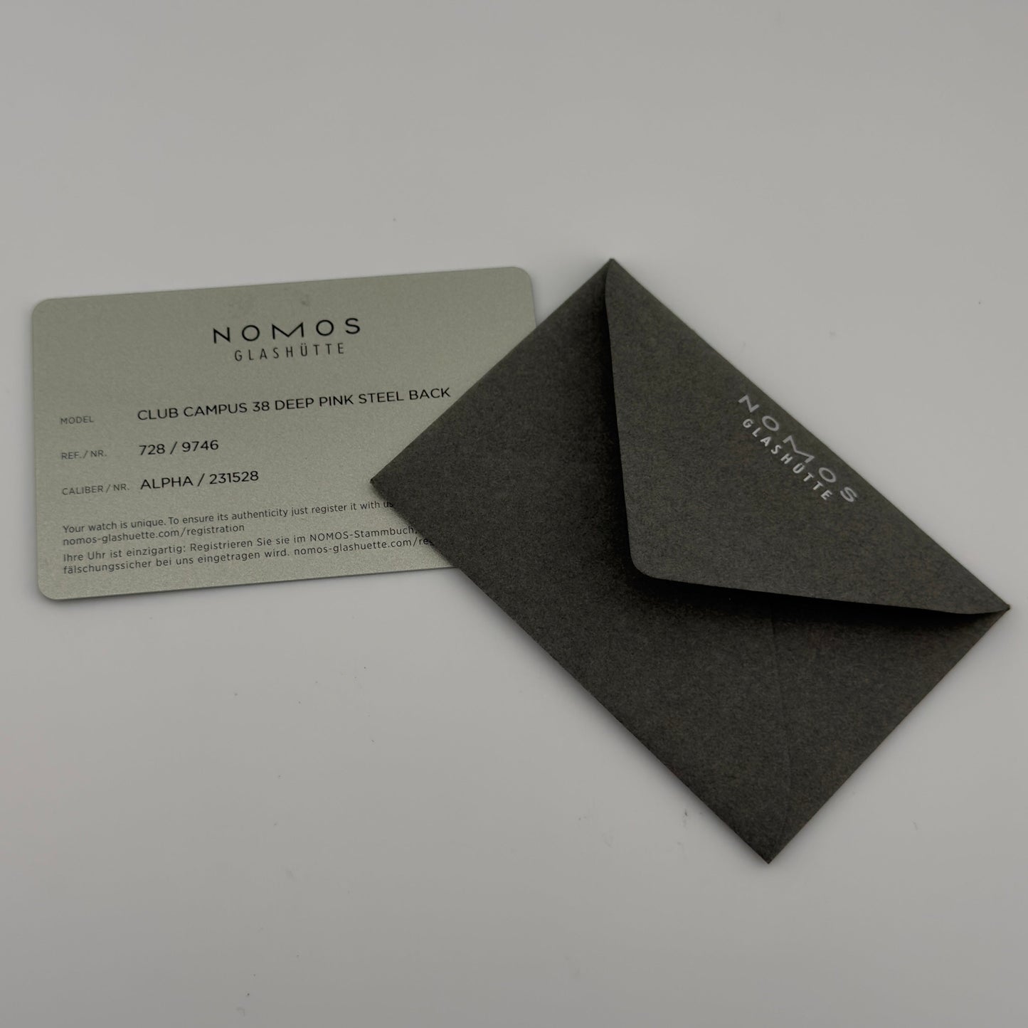 Black rectangular box with 'NOMOS GLASHÜtte' branding on a gray background