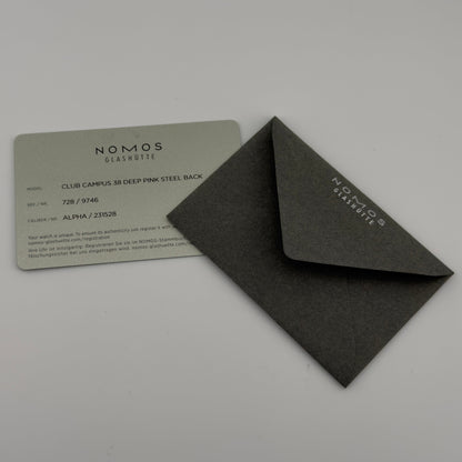 Black rectangular box with 'NOMOS GLASHÜtte' branding on a gray background