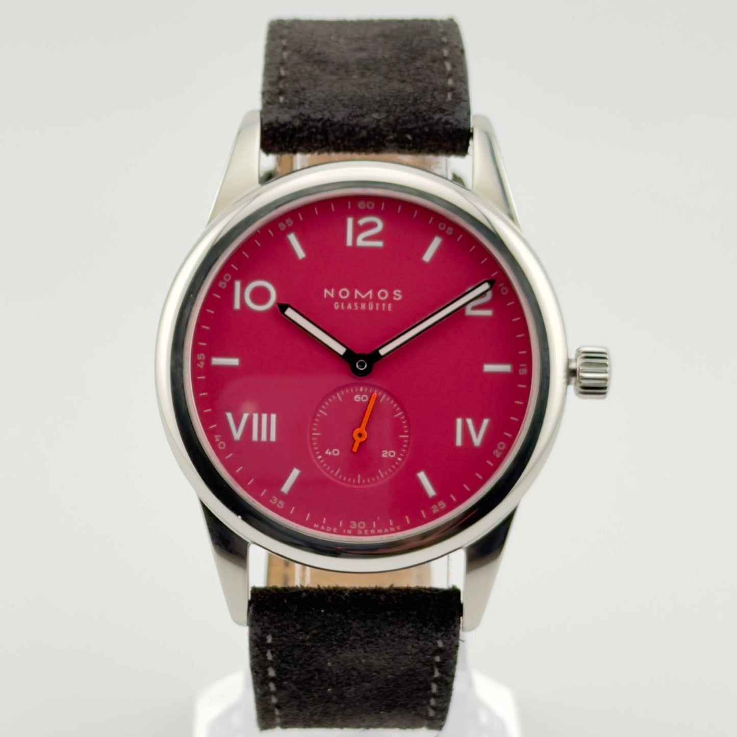 Wristwatch with red dial and black strap on a white background