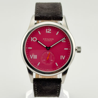 Wristwatch with red dial and black strap on a white background
