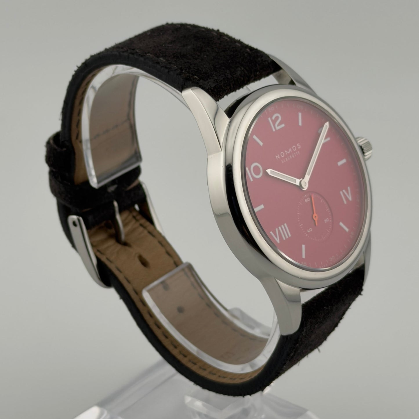 Wristwatch with black strap and red face on a gray background