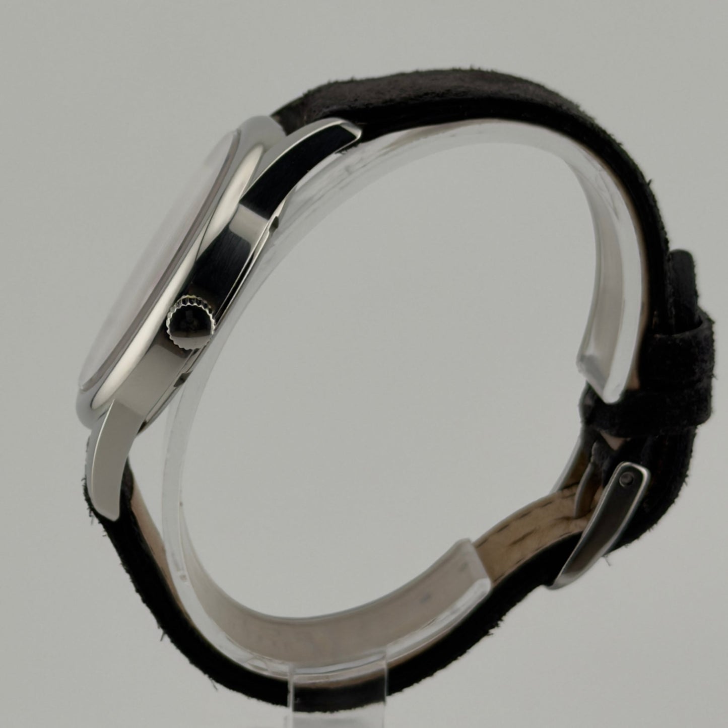 Close-up of a black leather bracelet with silver clasp on a gray background
