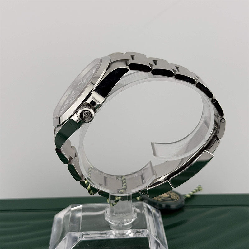 Silver watch on a clear stand against a gray background