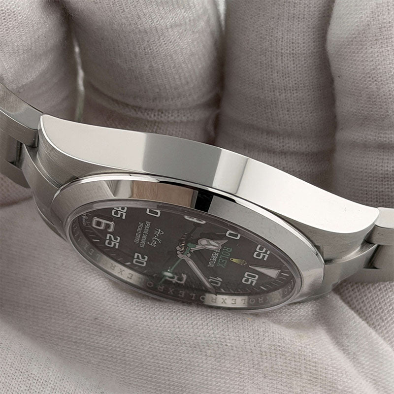 Silver watch with a detailed face on a light gray fabric background