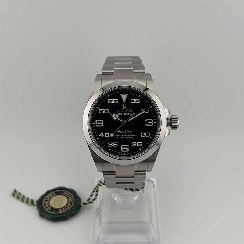Silver Rolex watch on a stand with a gray background